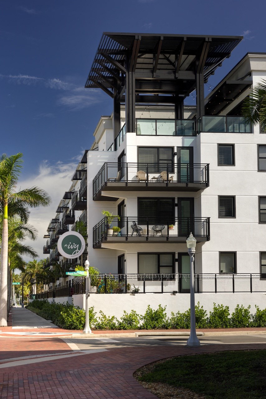 A white building with a balcony and a sign that says "lily".