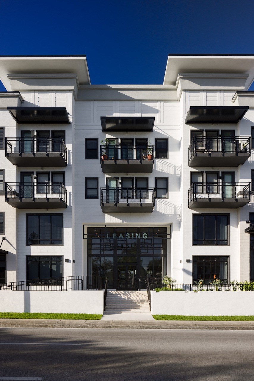 A white apartment building with the word "Leasing" on the front door.