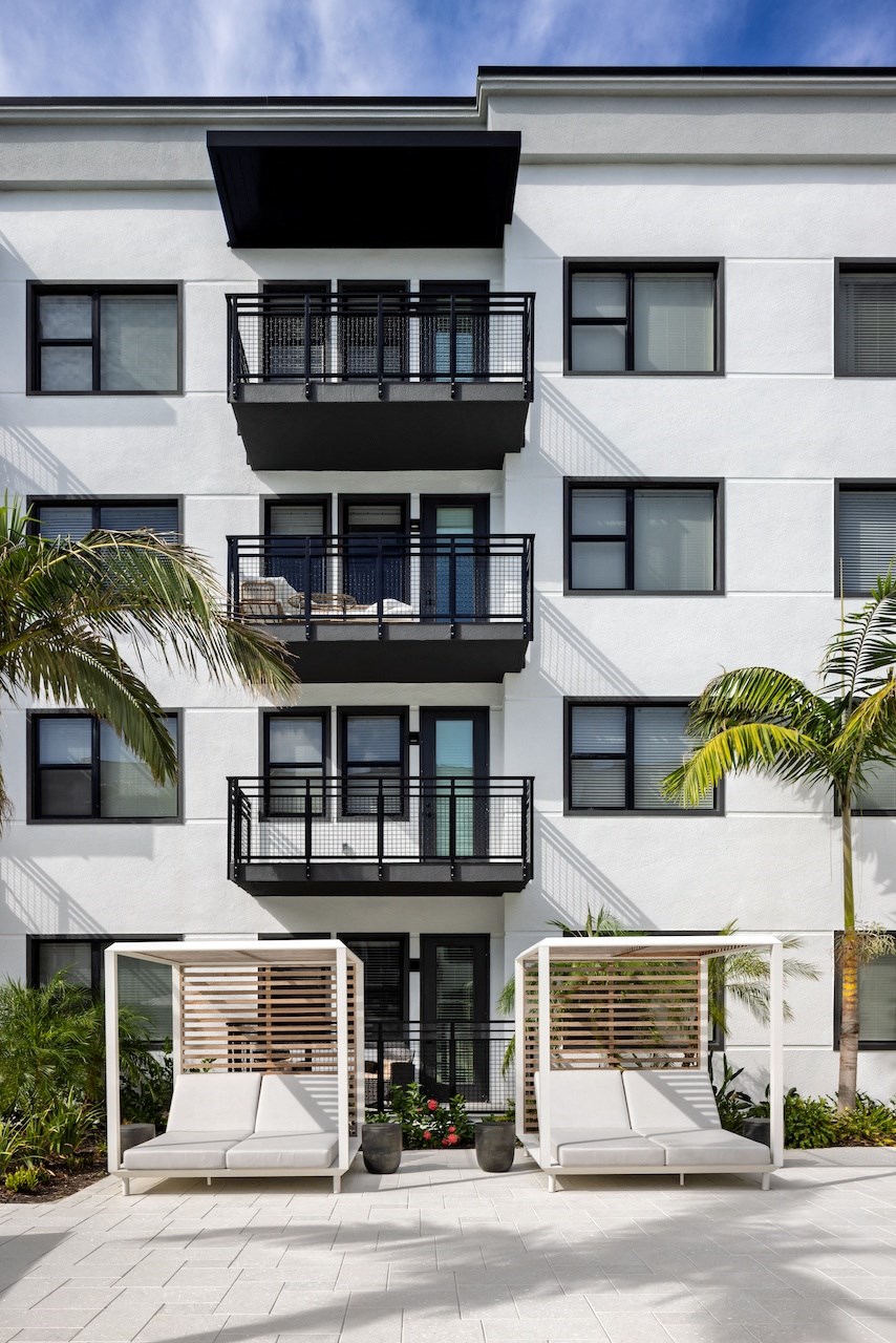 A white building with black railings and a balcony.