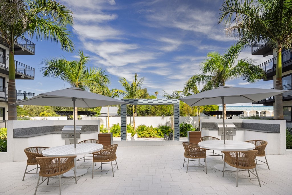 A patio with a table and chairs under umbrellas.