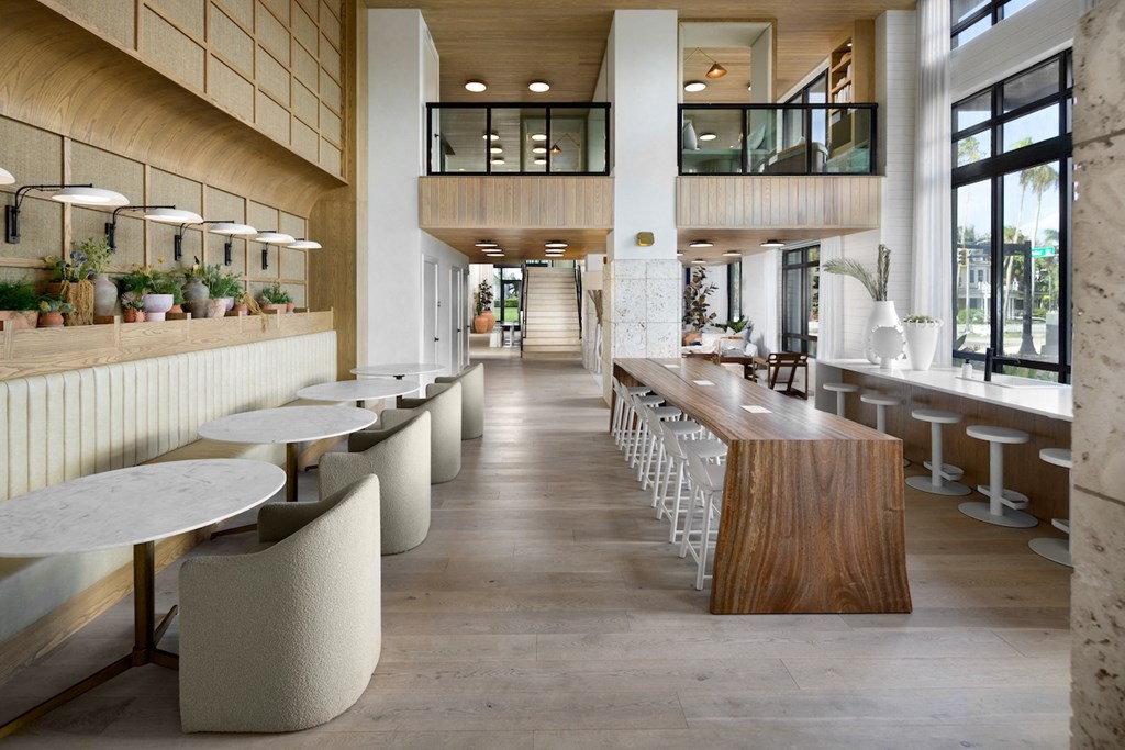 A long hallway with tables and chairs on either side.