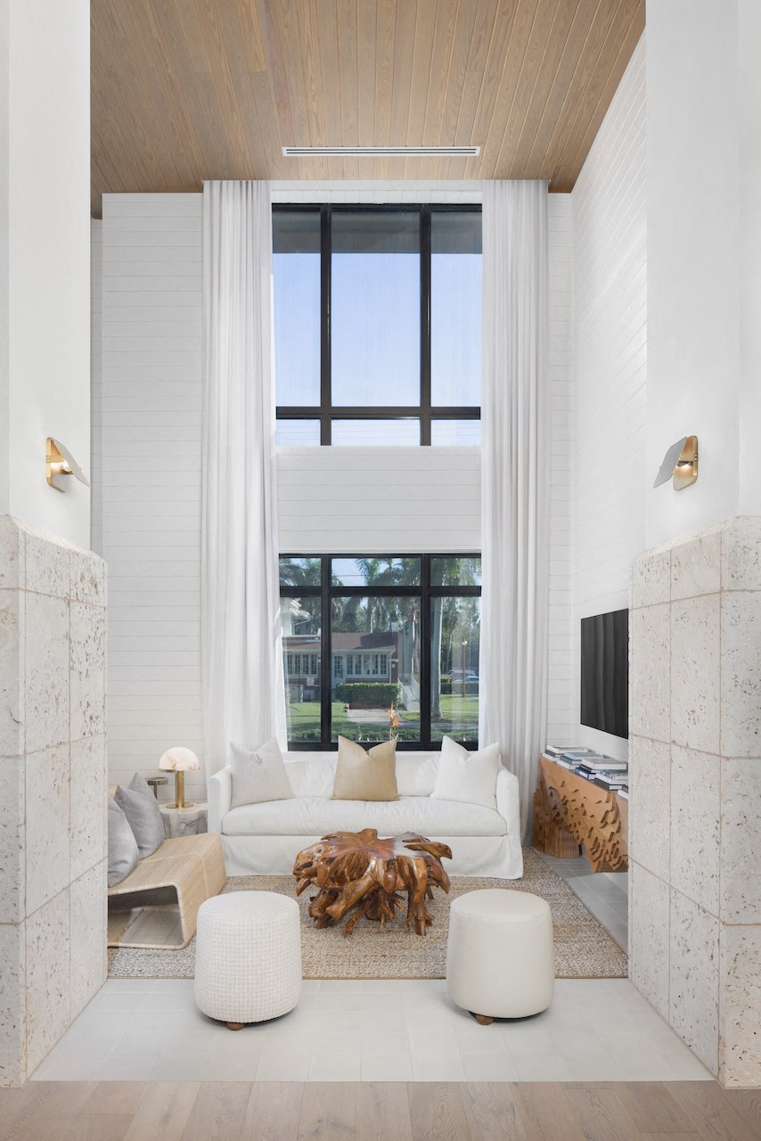 A modern living room with a large window and a white sofa.