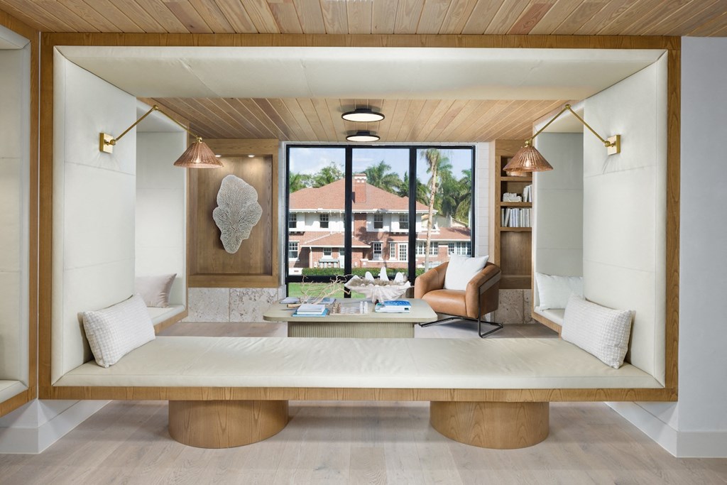 A modern living room with a large window and a wooden ceiling.
