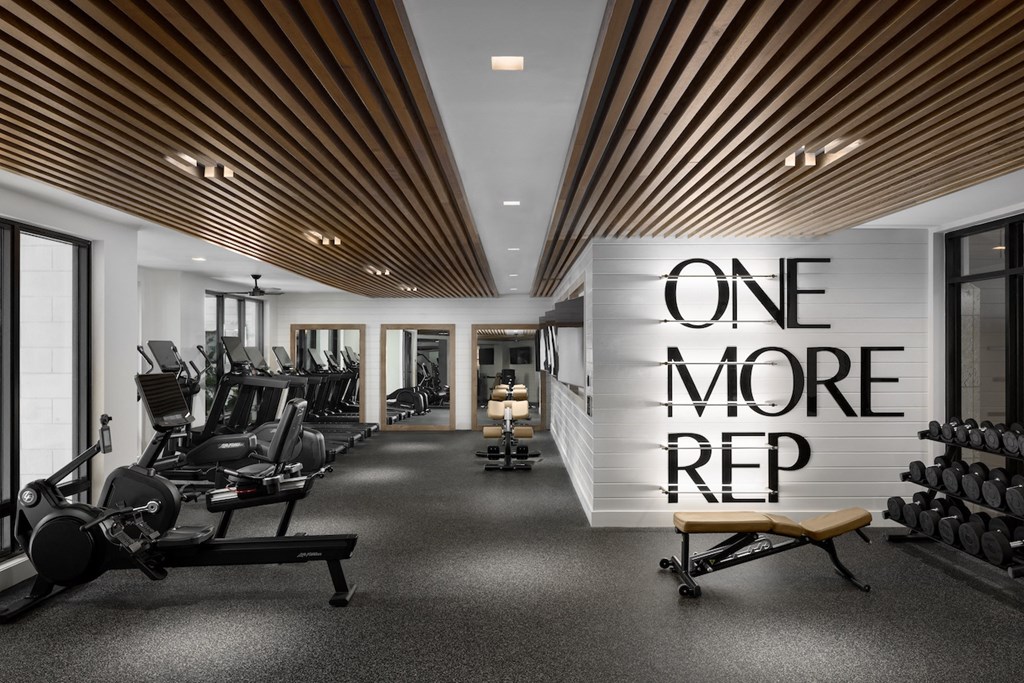 A gym with a sign that says "one more rep".