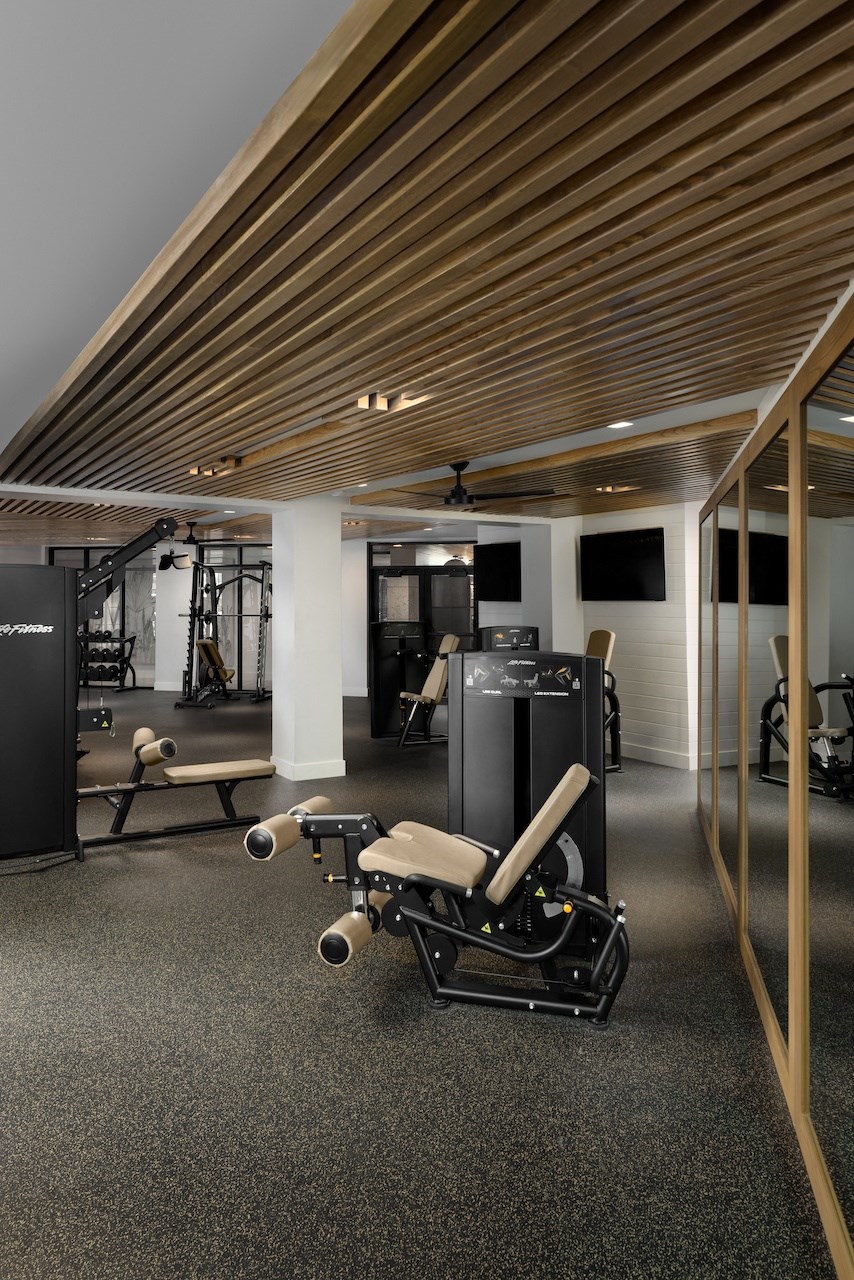 A gym with a variety of equipment including a rowing machine.