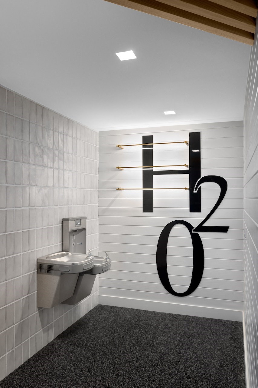 A bathroom with a toilet and a sign that says H2O.