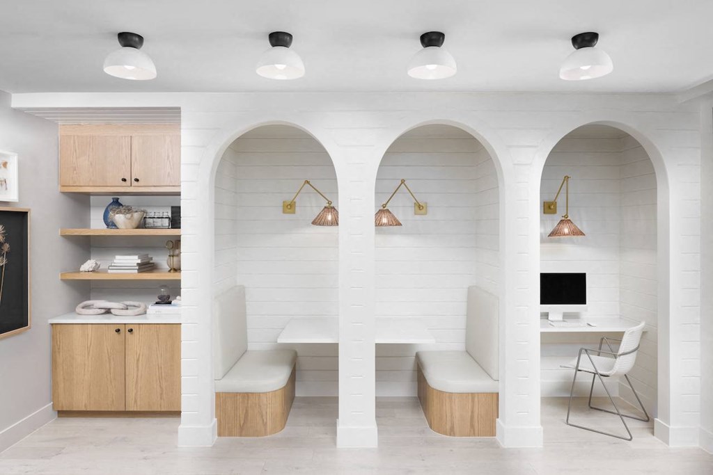 A white room with arched openings and a desk with a computer.