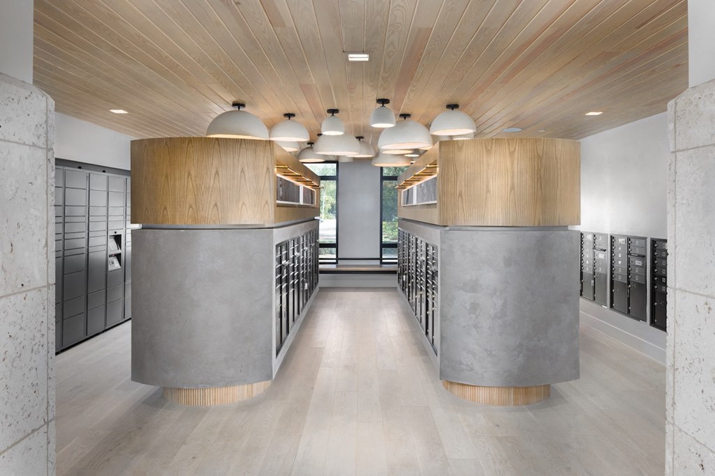 A modern hallway with wooden ceilings and concrete columns.