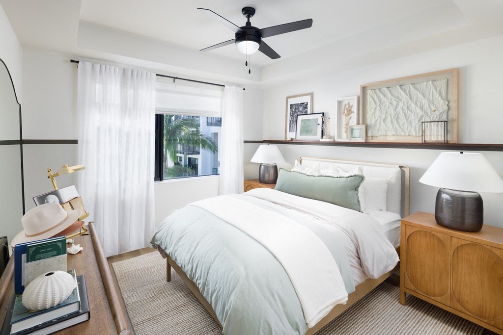 A bedroom with a large bed and a ceiling fan.