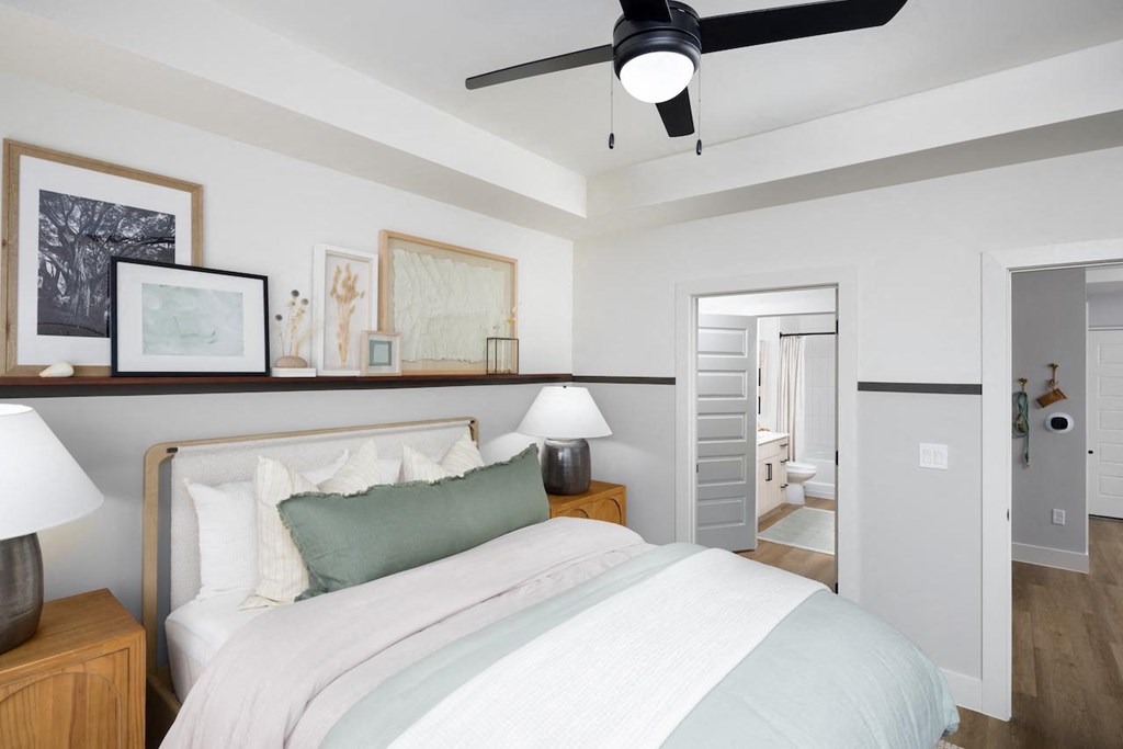 A bedroom with a bed, nightstand, and a ceiling fan.