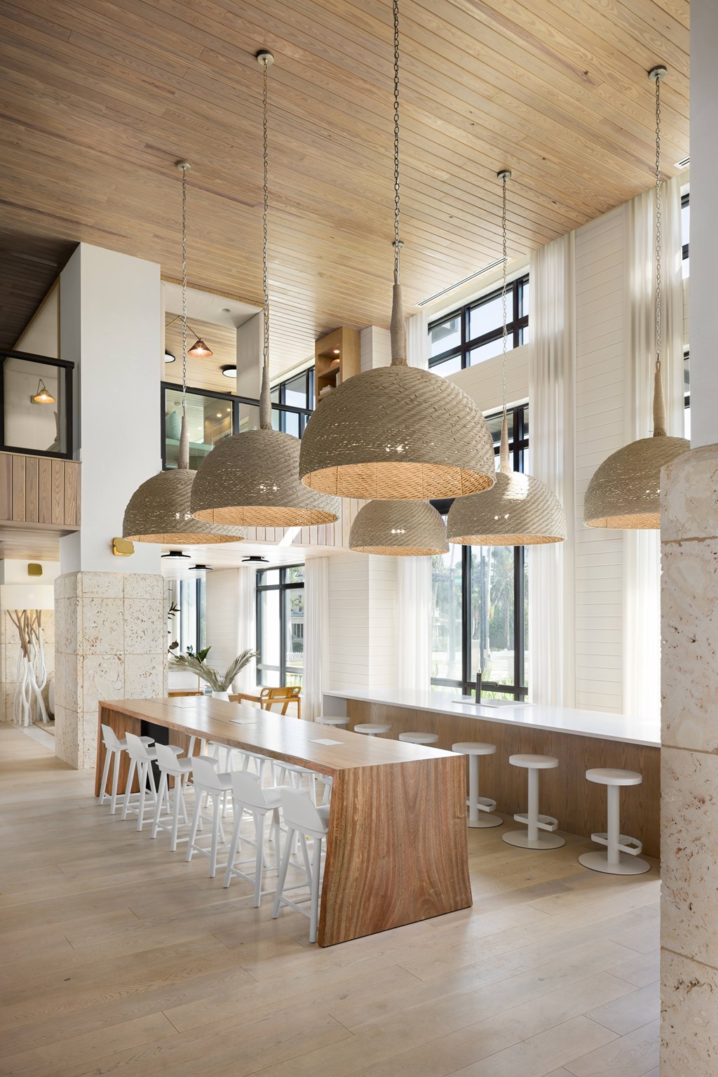 A modern interior with a bar area and hanging lights at The Ivy apartments in Fort Myers, FL.