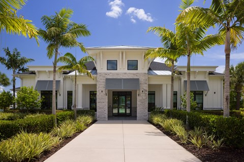 A white building with a grey roof and a walkway in front.