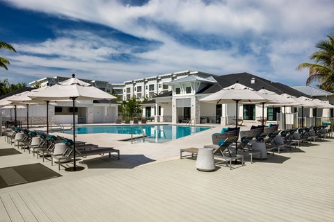A poolside area with sun loungers and umbrellas.