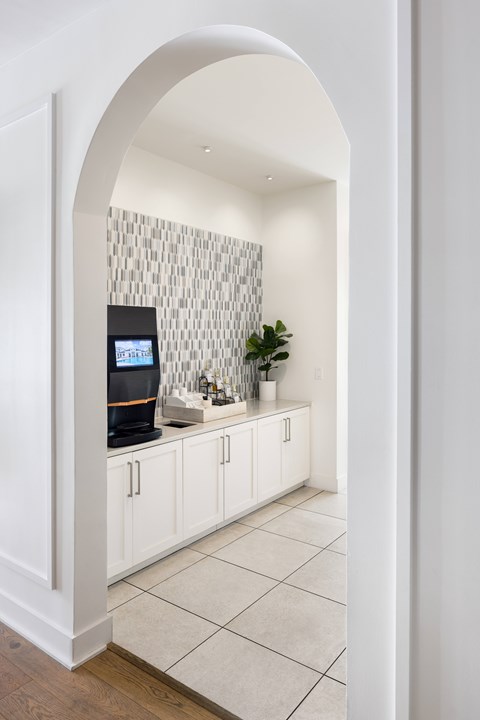 A kitchen with white cabinets and a tiled backsplash.
