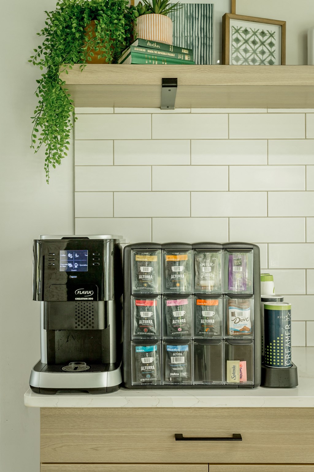 a white kitchen with a coffee machine and containers of coffee on a counter