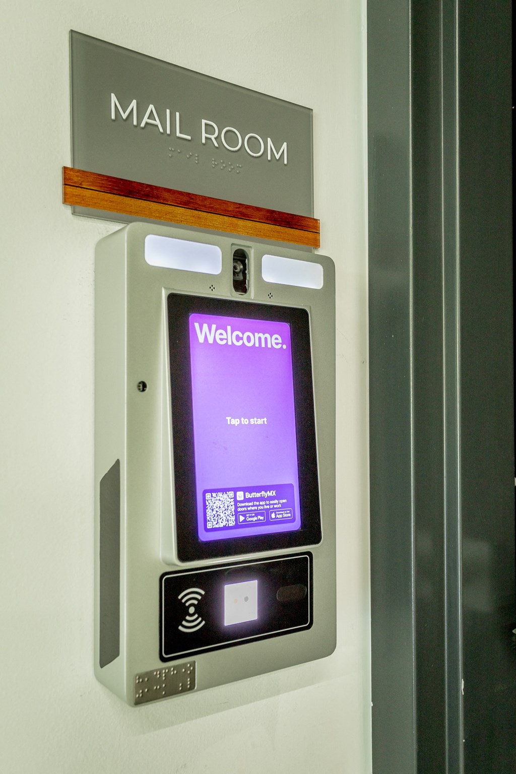 a door to a mail room with an ipad on the wall
