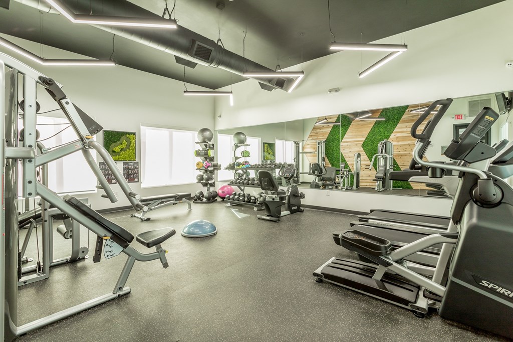 a gym with cardio equipment and weights on the floor of a building