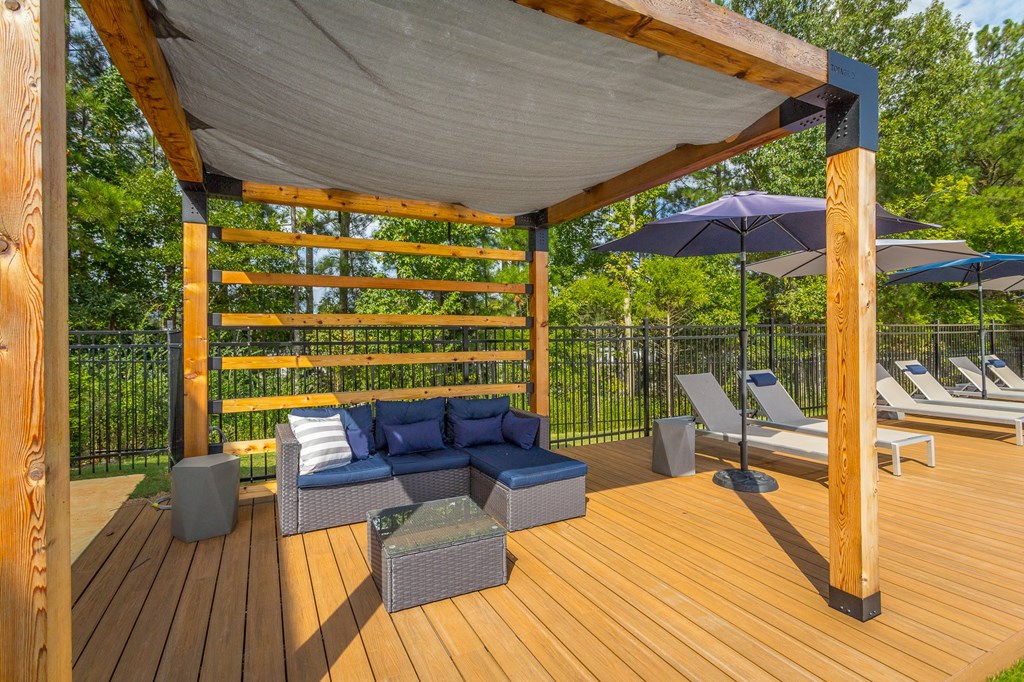 a covered deck with couches and umbrellas on it