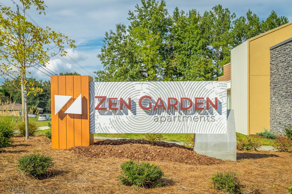 a sign for zen garden apartments in front of a building