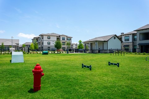 a red fire hydrant sitting in the middle of a grass field