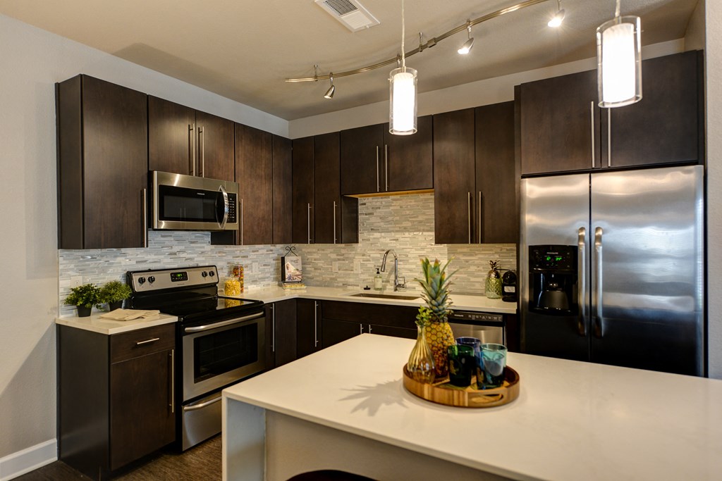 a kitchen with stainless steel appliances and a white counter top