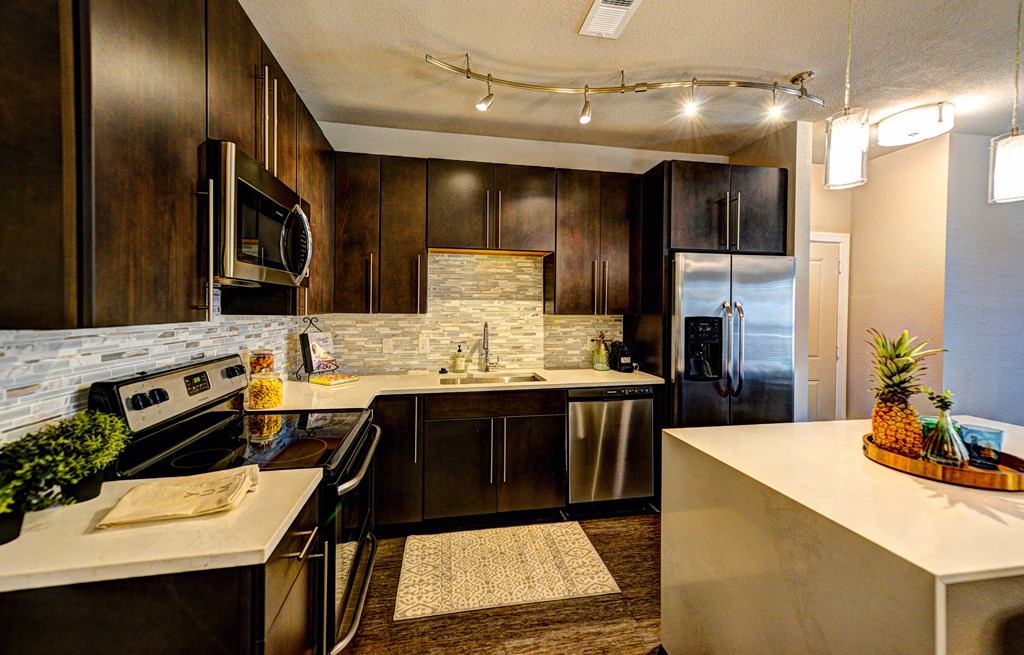 a kitchen with stainless steel appliances and dark wood cabinets