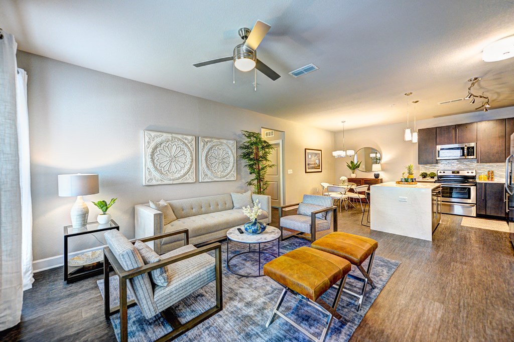 a living room and kitchen with a ceiling fan