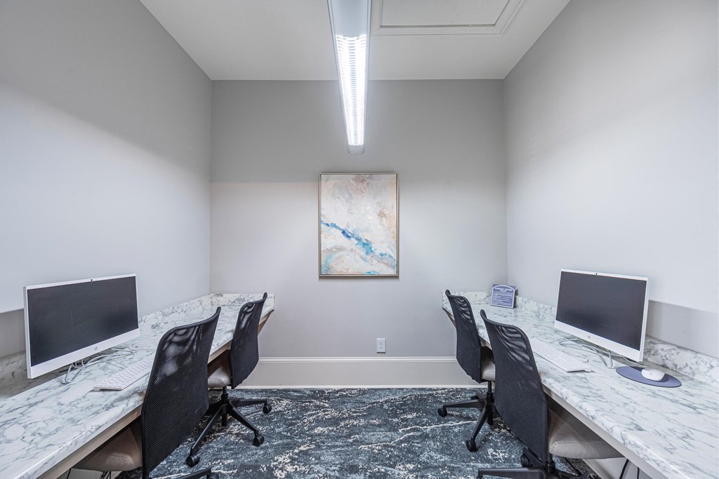 a conference room with two desks and two computer monitors