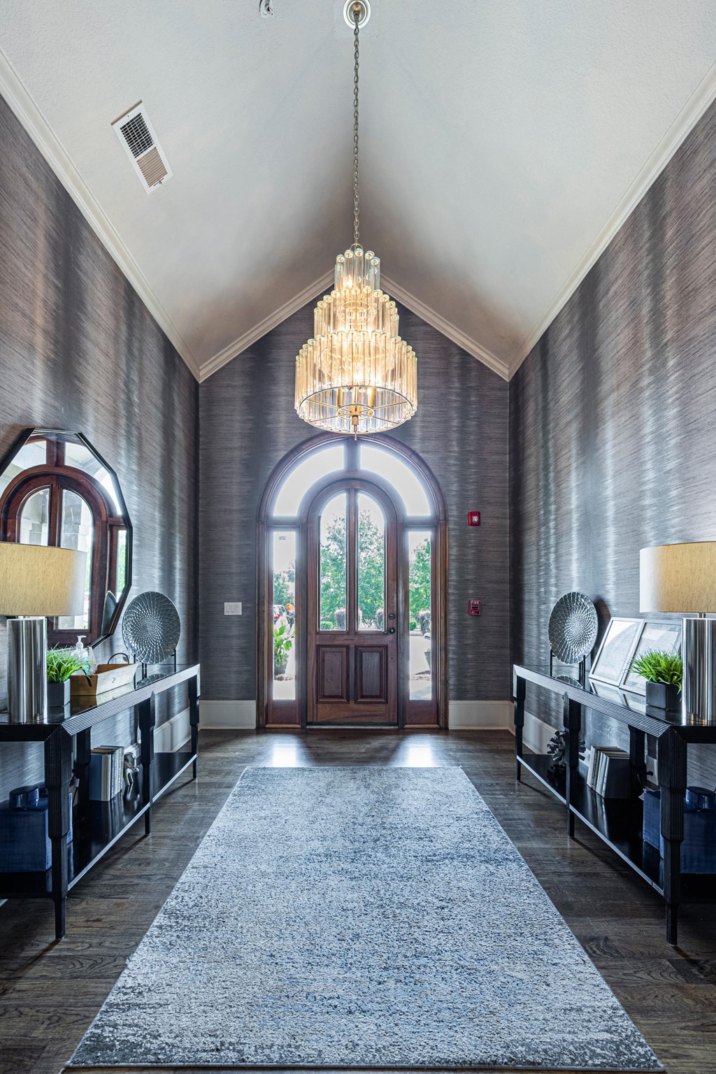 a hallway with a large door and a chandelier
