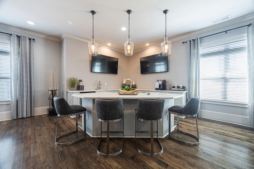 a kitchen with an island and chairs in front of a window