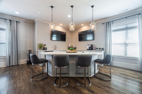 a kitchen with an island and chairs in front of a window
