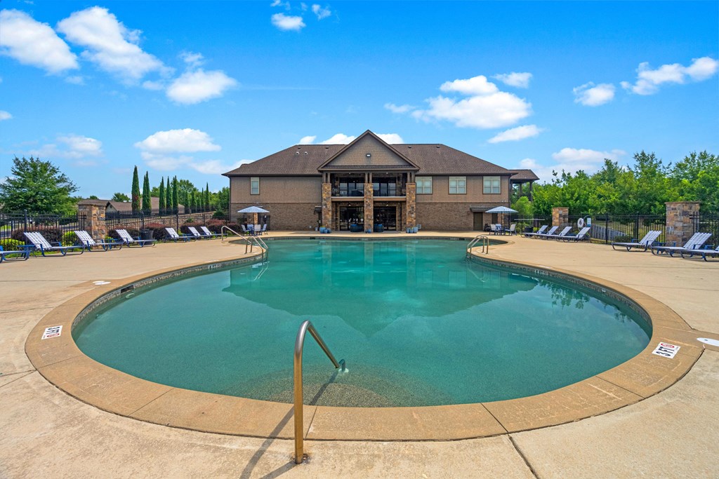 a swimming pool with a house in the background