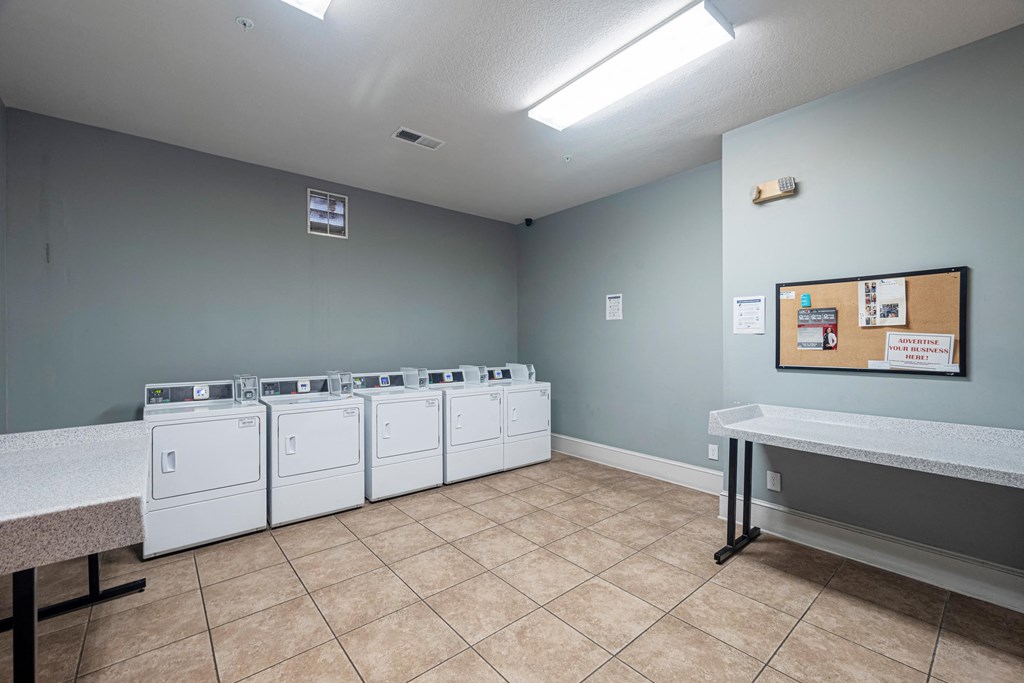 a laundry room with washers and dryers in it and a table with laundry