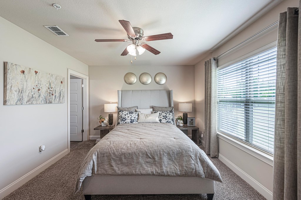 a bedroom with a large bed and a ceiling fan