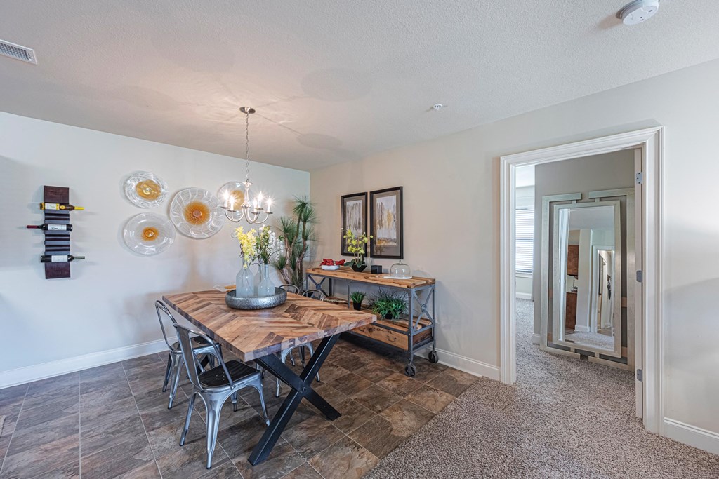 a dining room with a table and chairs and a mirror