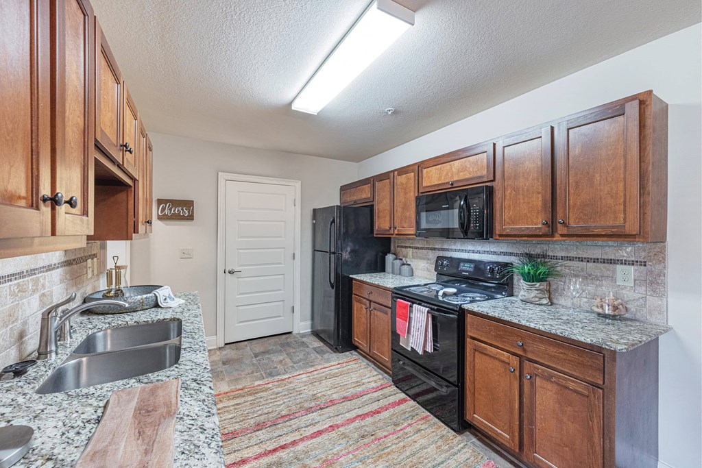 a kitchen with black appliances and wood cabinets