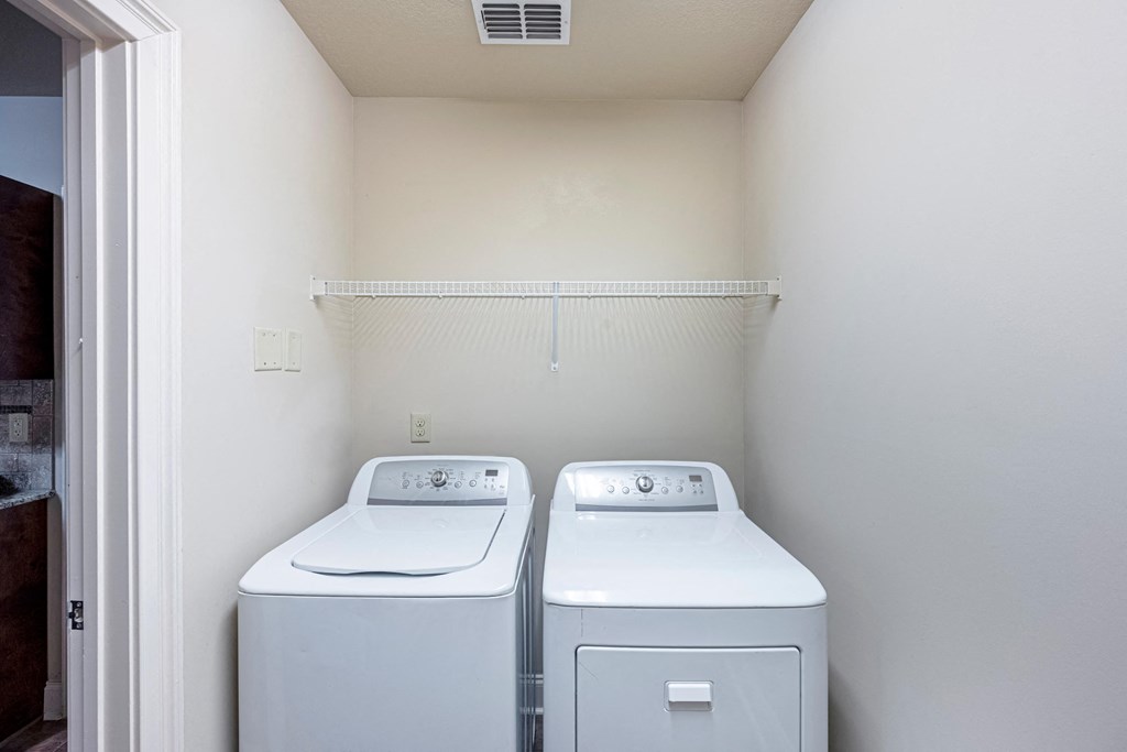 an empty laundry room with two washes and a dryer