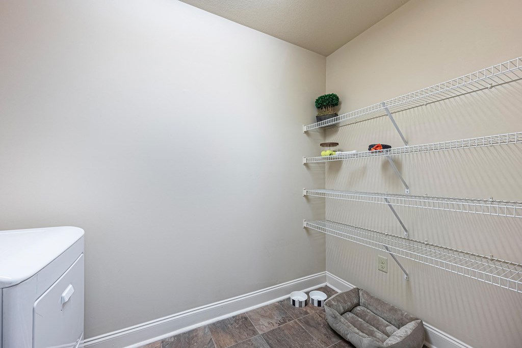 a laundry room with shelves and a washer and dryer