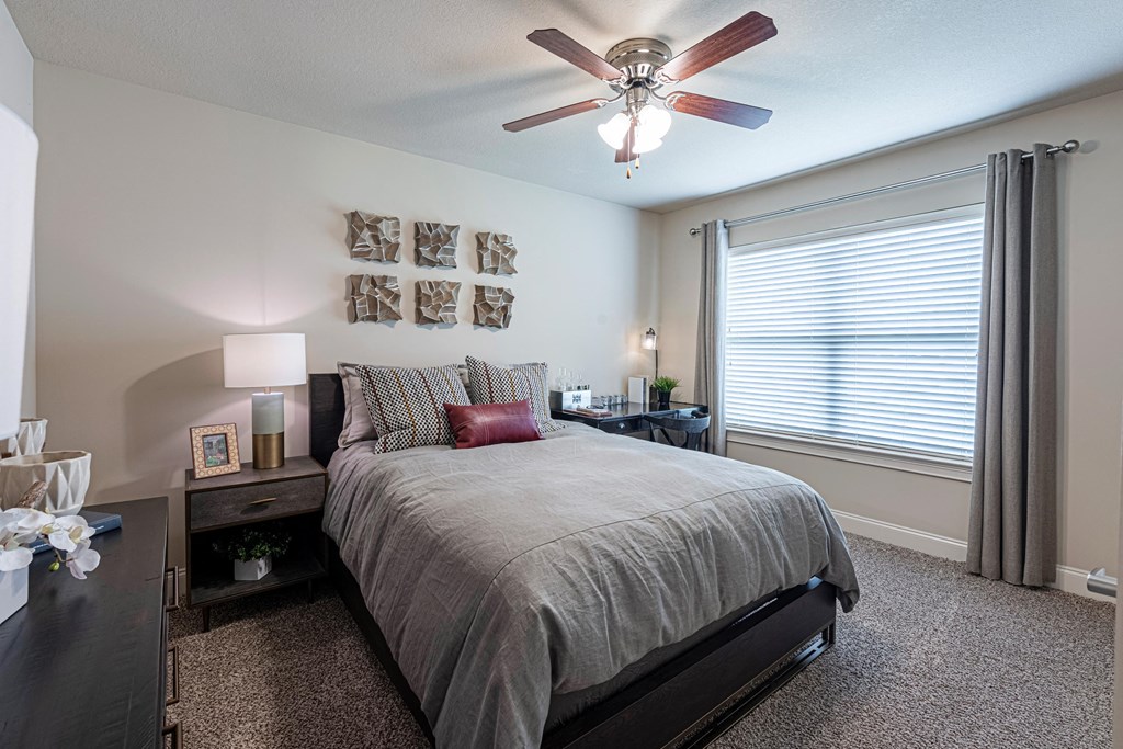a bedroom with a bed and a ceiling fan