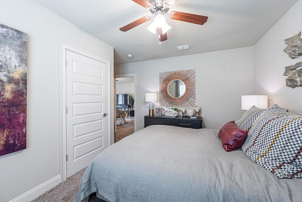 a bedroom with a large bed and a ceiling fan