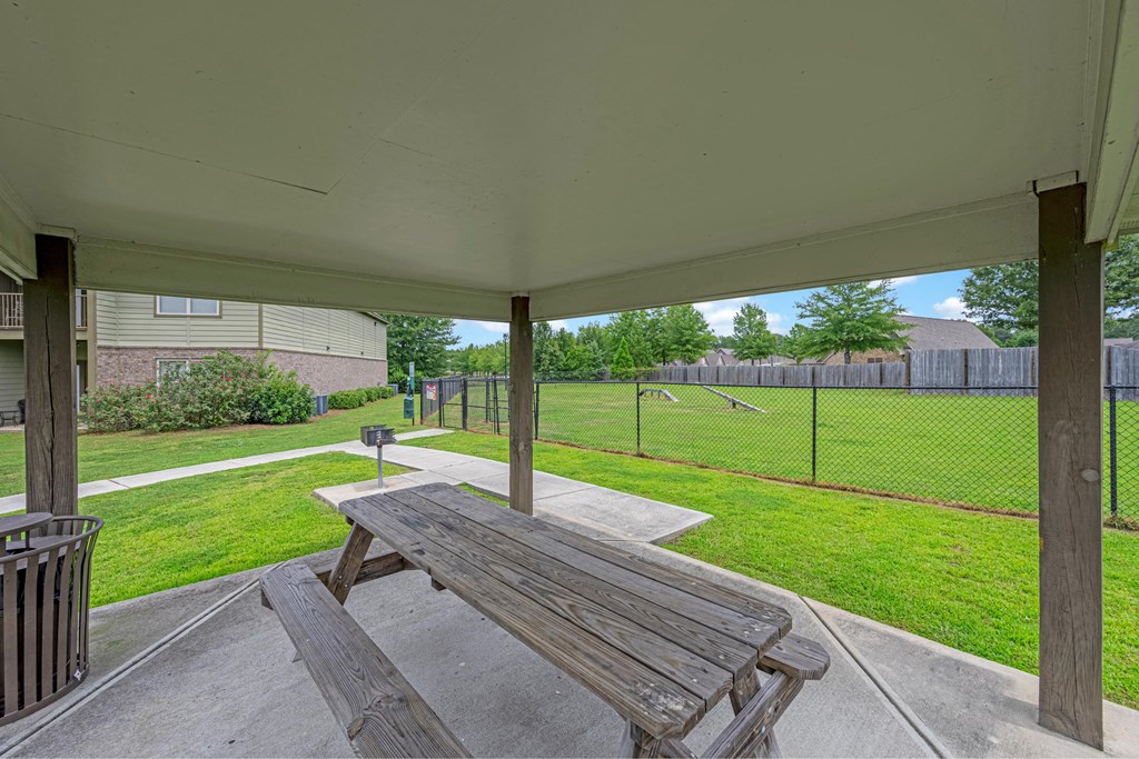 a patio with a picnic table and a fenced in yard