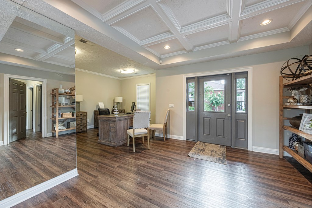 a remodeled living room with a wood floor and a gray door