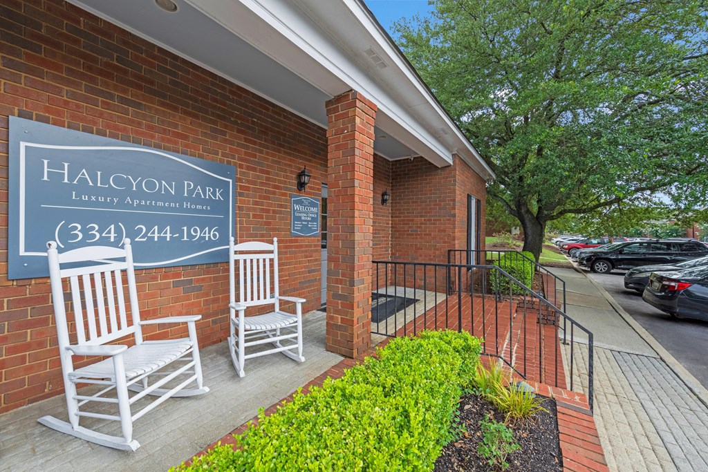 the entrance to halcyon park with two rocking chairs in front of a building