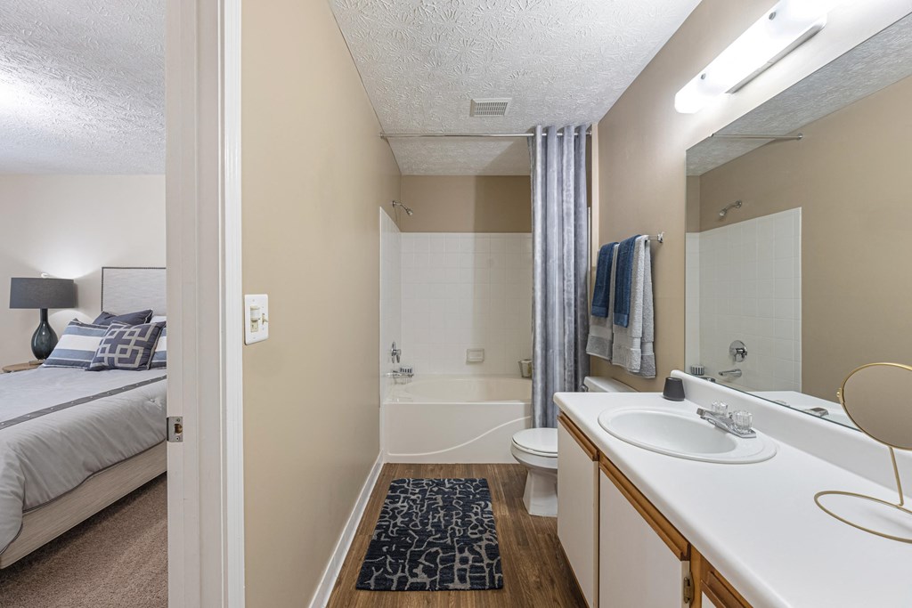 a bathroom with a shower and a sink and a toilet in a bedroom