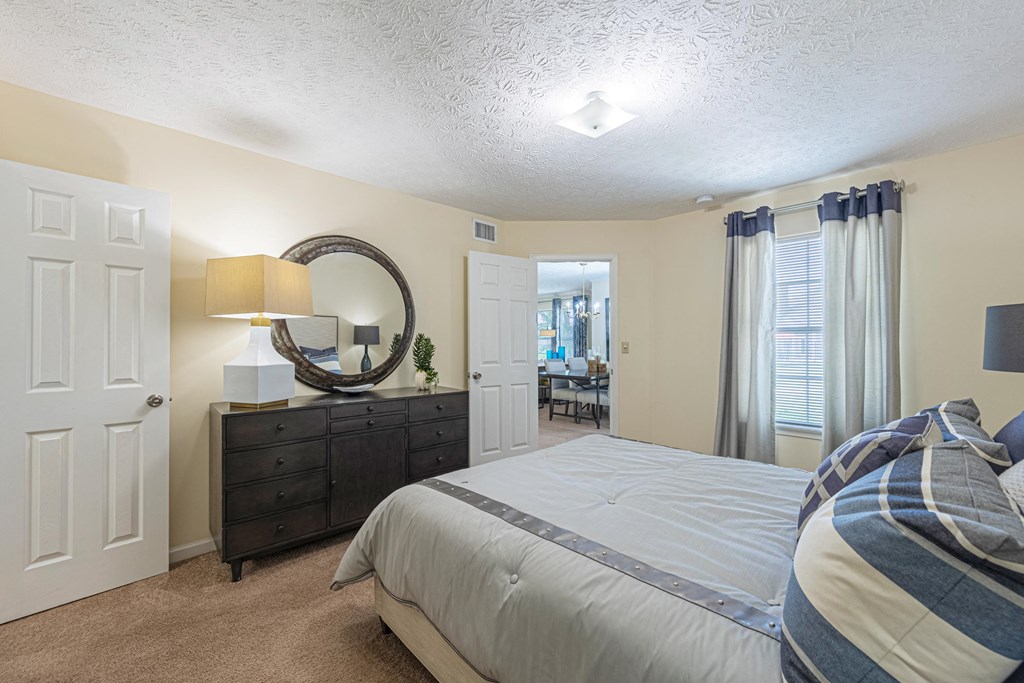 a bedroom with a bed and a dresser and a mirror