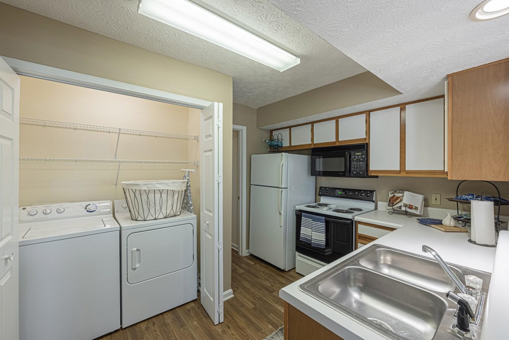 a kitchen with a washer and dryer and a sink and a refrigerator
