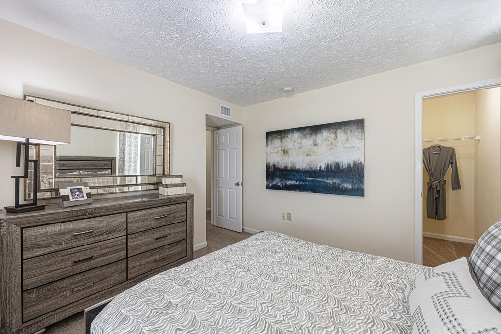 a bedroom with a bed and a dresser and a mirror