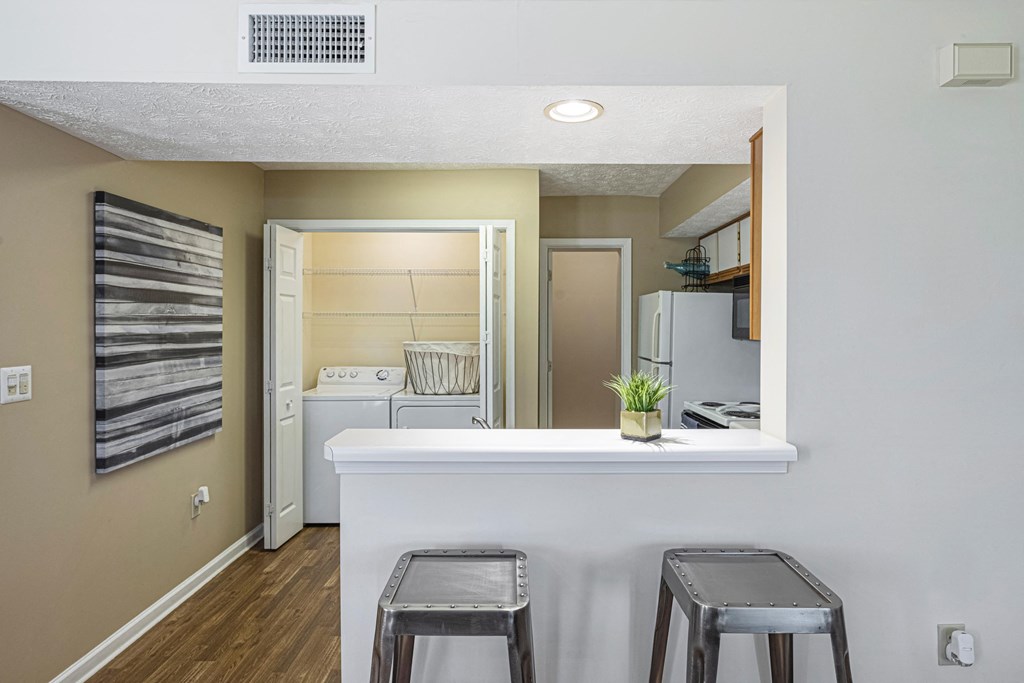 a kitchen with stools and a bar with two stools