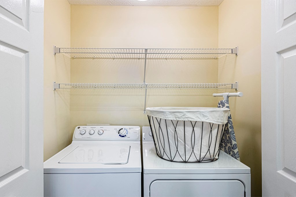 a washer and dryer in a laundry room with a basket on the top