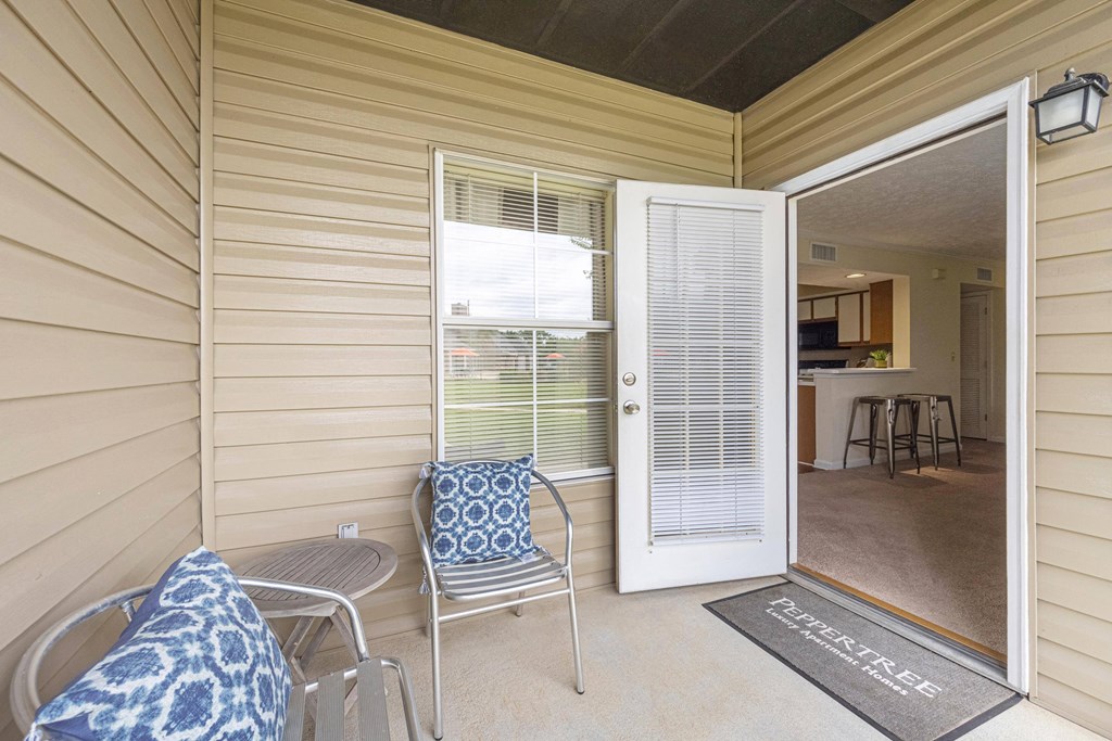 a patio with chairs and a door to a kitchen